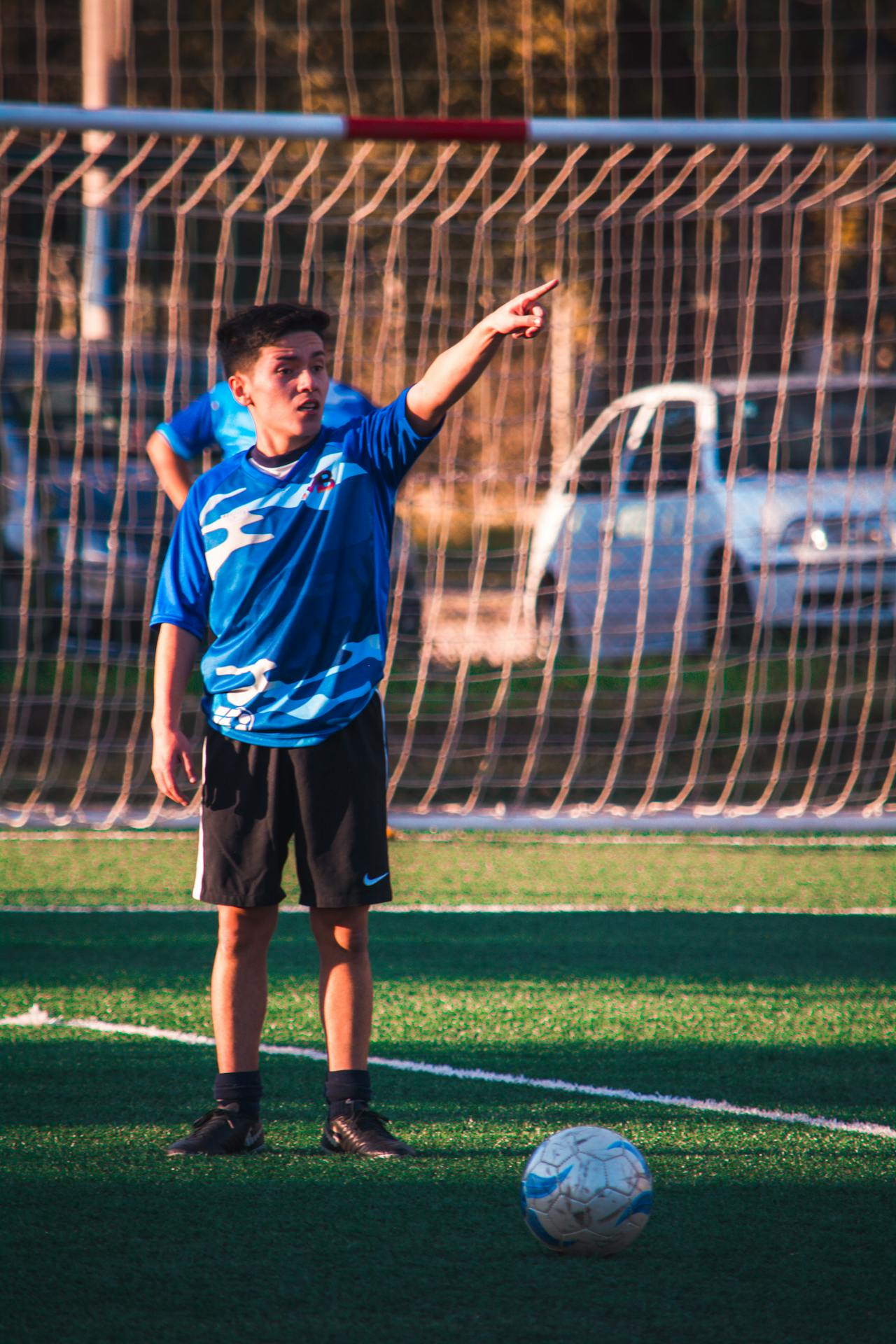 Young footballer directing play beside the goal